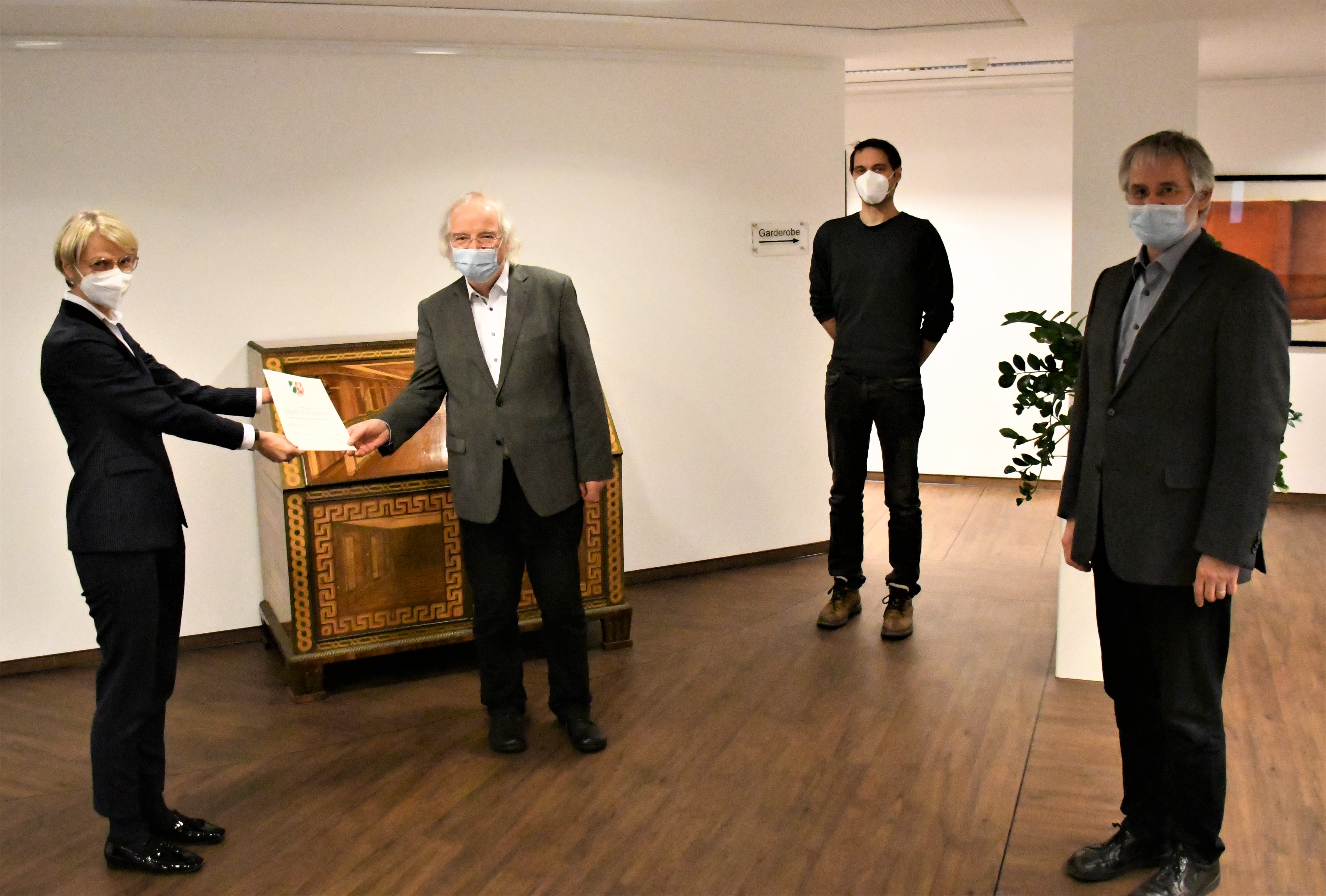 Regierungspräsidentin Dorothee Feller,
Pfarrer em. Heinz-Georg Surmund,
Michael Tremmel und Benedikt Surmund bei der Übergabe der Urkunde